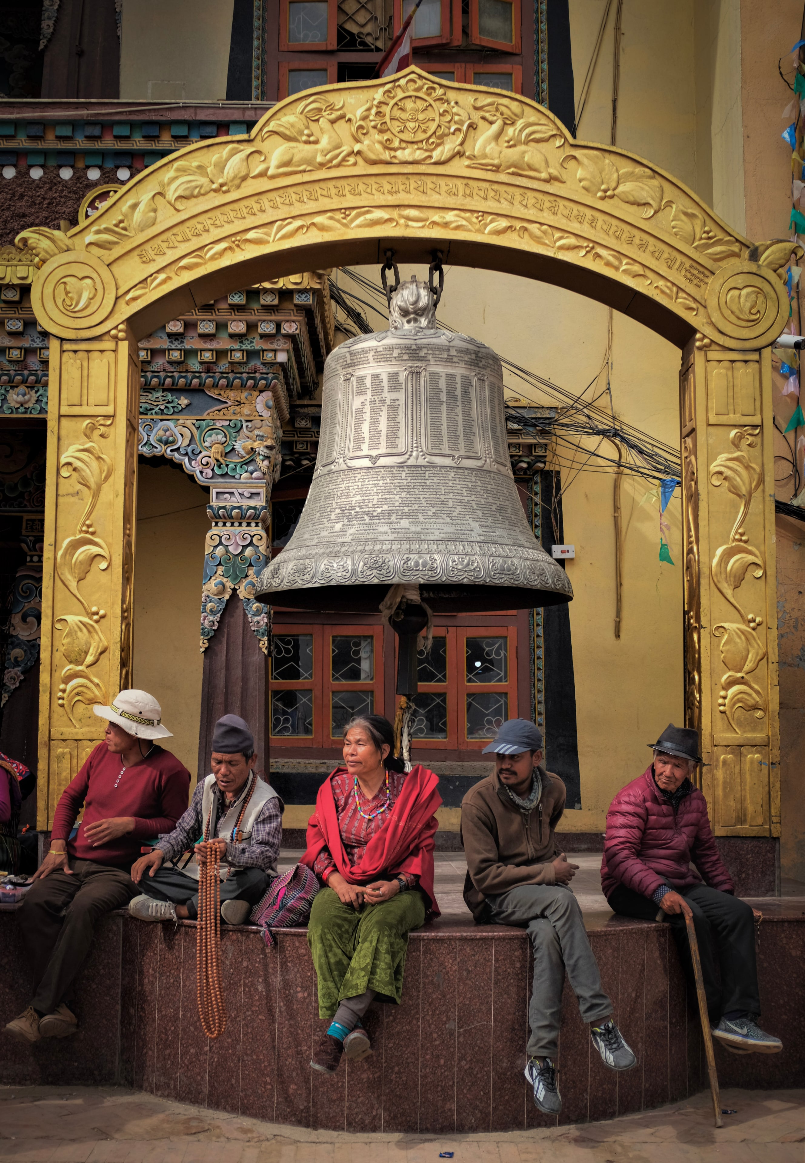 A temple bell, people resting on the steps